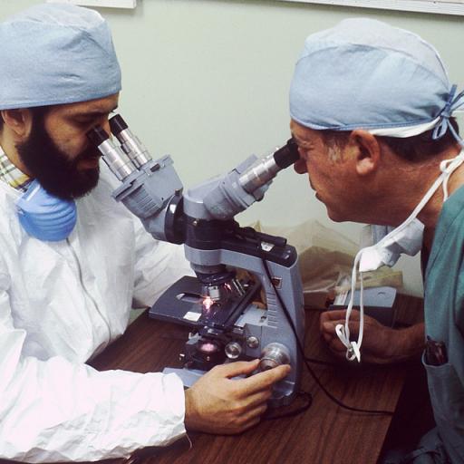 Tow doctors looing into a complex microscope